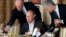 FILE - In this Nov. 11, 2011, photo, businessman Yevgeny Prigozhin, left, serves food to Russian Prime Minister Vladimir Putin, center, during dinner at Prigozhin's restaurant outside Moscow. 