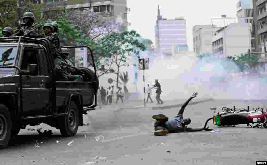 A supporter of Kenyan opposition National Super Alliance (NASA) coalition lies on the ground after he was hit by a police truck during a protest along a street in Nairobi.