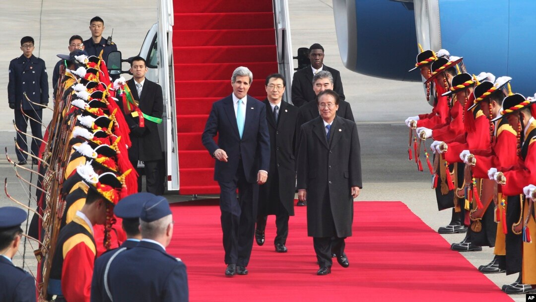 Menlu AS John Kerry (tengah kiri) melewati pesukan kehormatan bersama Wakil Menlu Korea Selatan Lee Kyung-soo (tengah kanan) setibanya di bandara militer di Seongnam, Seoul, Korea Utara (13/2).