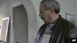 A Tunisian examines a lampshade in one of the mansions owned by family of ousted long-time Tunisian dictator President Zine El Abidine Ben Ali, January 2011