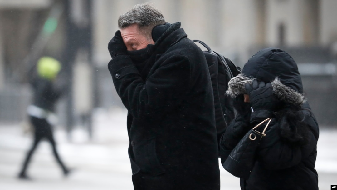 Commuters brave the wind and snow in frigid weather in Cincinnati, Ohio, Jan. 30, 2019. 