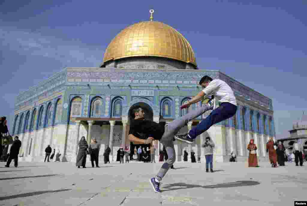 The Dome of the Rock is seen in the background as Palestinian youths practice their parkour skills during Friday prayers in Jerusalem&#39;s Old City.