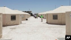 The undated photo released by U.S. Department of Health and Human Services shows detainees walk in a line at the HHS' unaccompanied alien children program facility at Tornillo, Texas. 