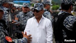 FILE - Vice President of El Salvador Oscar Ortiz greets members of the Special Reaction Force, a combined army-police unit, during a ceremony prior to their deployment to deal with gang violence in San Salvador, El Salvador, Oct. 20, 2016. 