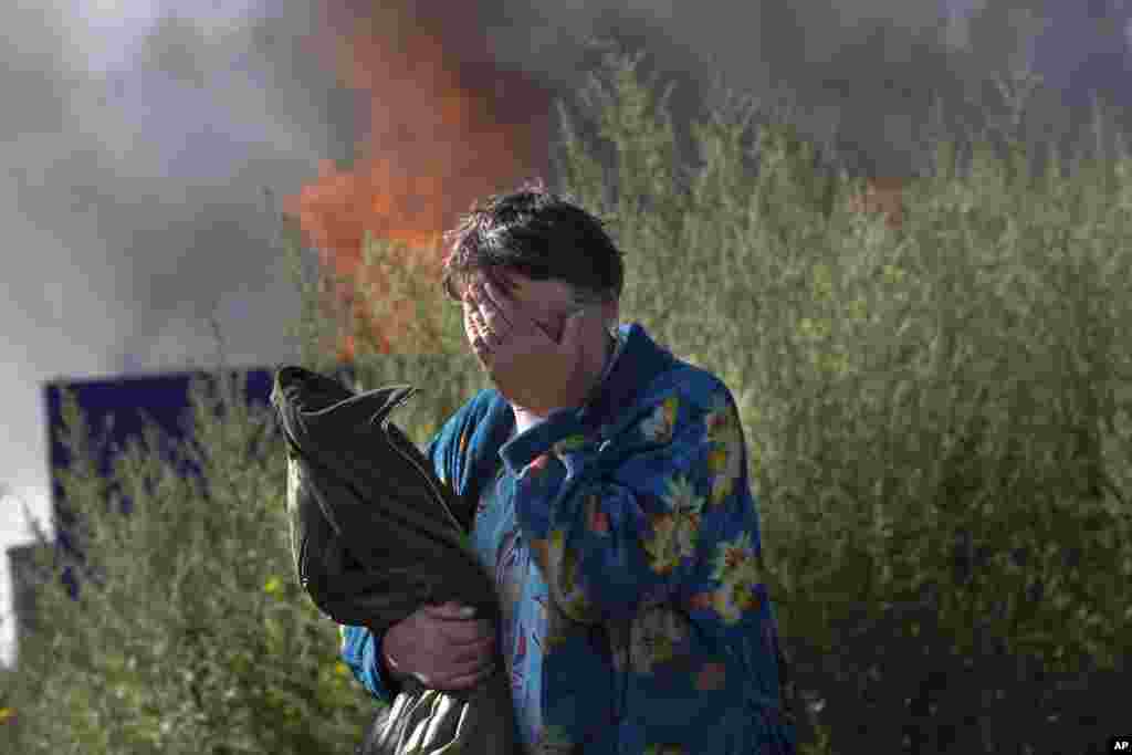 A woman cries near her burning house after it was shelled, in the city of Slovyansk, June 30, 2014.