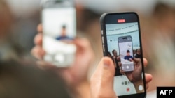 A person takes a video showing new iPhone 16 Pro features following Apple's "It's Glowtime" event in Cupertino, California, Sept. 9, 2024.