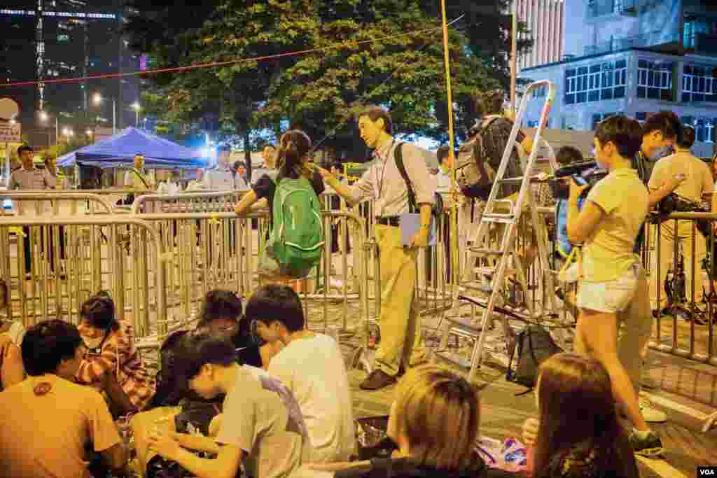 周日晚9点多，美国之音驻香港记者海彦在特首办公室入口处采访抗议学生 (美国之音方正拍摄)