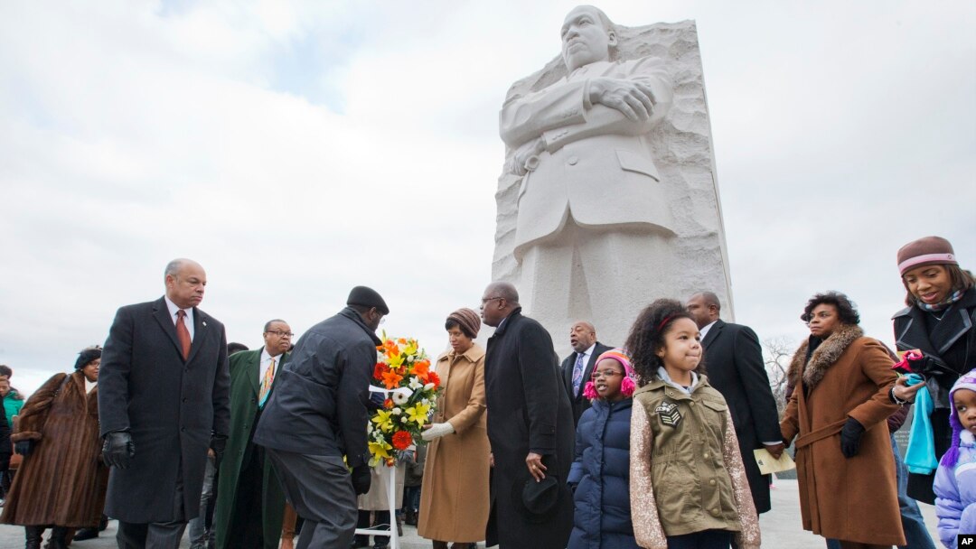 Menteri Keamanan Dalam Negeri AS, Jeh Johnson (kiri) meletakkan karangan bunga di depan patung Dr. Martin Luther King, Jr. hari Senin (19/1).