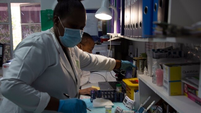 FILE - Laboratory technicians test a blood sample for HIV infection at the Reproductive Health and HIV Institute (RHI) in Johannesburg, Nov. 26 2020.