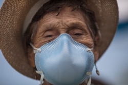 Ubaldina Calderon, 92, exits a clinic after receiving a pneumonia vaccine, in Lima, Peru, March 13, 2020. The Ministry of Health is encouraging seniors to get a pneumonia vaccine to reduce the risks of those who might contract the new coronavirus.