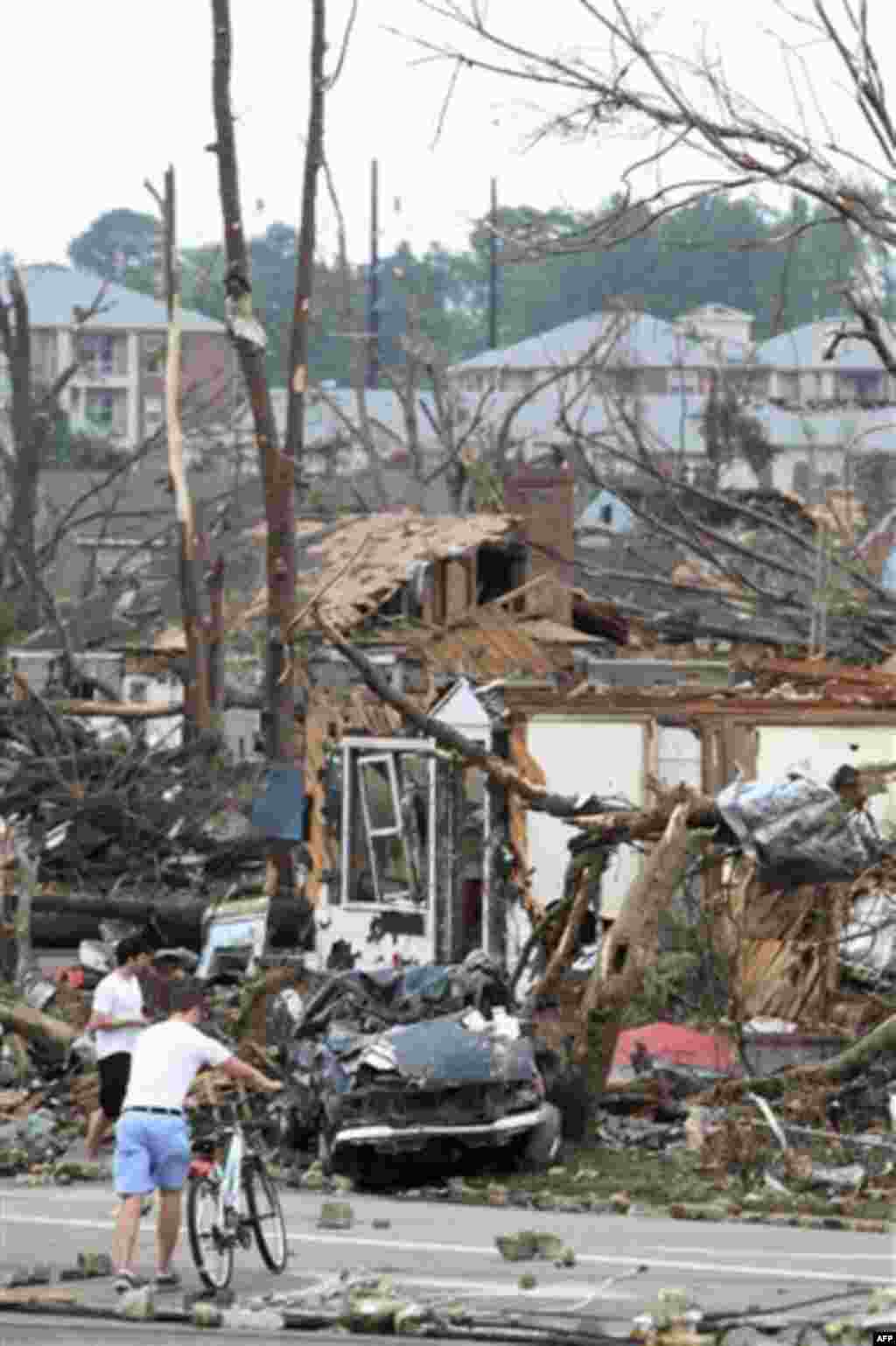 Residents take stock of the damage after a strong tornado ripped through Tuscaloosa, Ala., Wednesday afternoon, April 27, 2011. A wave of severe storms laced with tornadoes strafed the South on Wednesday, killing at least 16 people around the region and s