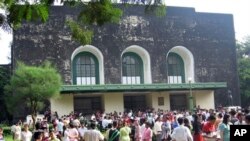 In this photo taken on Oct. 2, 2005, graduated students and family members gather outside the convocation hall in the main campus of Yangon University during a graduation ceremony in Yangon, Myanmar. The university was once one of Asia's finest and a poig