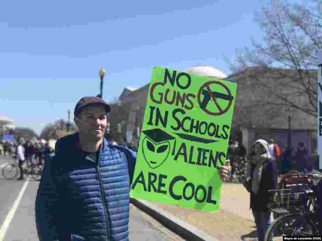 Cartazes criativos fizeram slogans na Marcha Pelas Nossas - "Escolas sem armas, Extra-terrestres são fixes"