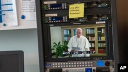 Pope Francis is seen on a video screen at U.N. headquarters as he speaks in a pre-recorded message addressing the 75th session of the General Assembly, Sept. 25, 2020. 