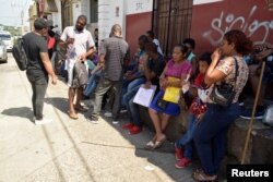 Migrants from Central America and Cuba line up outside the Mexican Commission for Refugee Assistance to apply for asylum and refugee status in Tapachula, Mexico, Sept. 13, 2019.