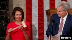 FILE PHOTO: House Speaker-designate Nancy Pelosi (D-CA) is handed the gavel by House Republican Leader Kevin McCarthy as the U.S. House of Representatives meets in Washington