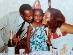 A young Karine Jean-Pierre celebrates with her parents in this undated photo from Facebook.