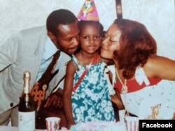 A young Karine Jean-Pierre celebrates with her parents in this undated photo from Facebook.