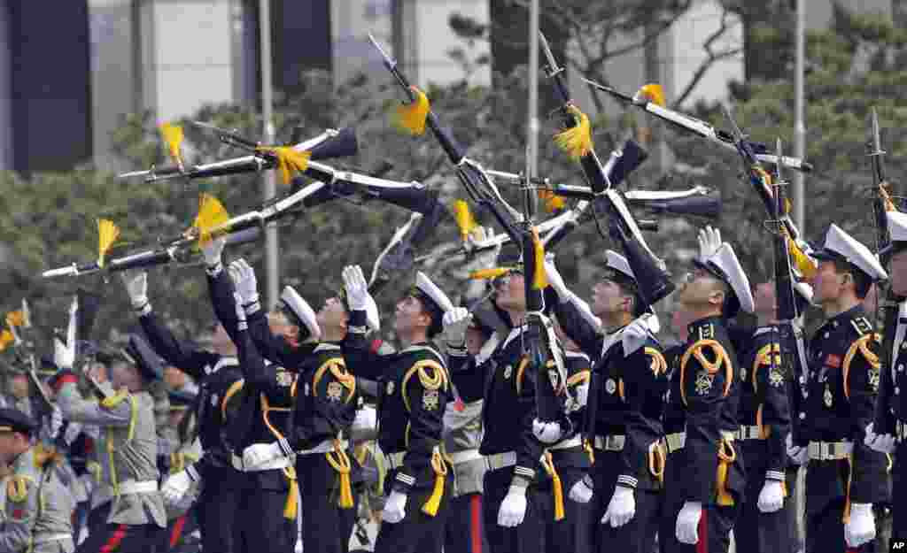 Members of a South Korean honor guard throw their rifles in the air during a weekly demonstration at the War Memorial of Korea in Seoul.