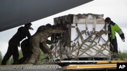 U.S. soldiers unload medical aid from the United States, including ventilators, to help the country tackle the coronavirus outbreak, after a U.S. Air Force plane landed near Moscow, June 4, 2020.