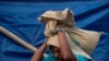 A Rohingya man carries relief aid at a camp in Teknaf, Bangladesh, Aug. 21, 2019. 