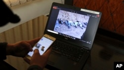Shoaib, whose father and 13 others were killed in Afghanistan’s central Ghor Province by gunmen in 2014, seen on screen, speaks to The Associated Press in Kabul, Afghanistan, Feb. 9, 2018. 