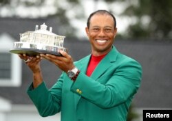 FILE - Tiger Woods celebrates after winning the 2019 Masters, at Augusta National Golf Club in Augusta, Georgia, April 14, 2019.