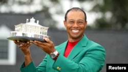 Tiger Woods of the U.S. celebrates with with his green jacket and trophy after winning the 2019 Masters. He was injured in a car accident on February 23, 2021. (REUTERS/Lucy Nicholson) 