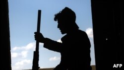 FILE - A member of the Kurdish People's Protection Units (YPG) holds a weapon in the Syrian city of Raqqa, June 21, 2017, during an offensive by US-backed fighters. 