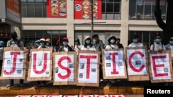 Para pedemo membentangkan poster bertuliskan "Justice (keadilan)" dalam demo memprotes kudeta militer terhadap pemerintah sipil Myanmar, di Yangon, Myanmar, Senin, 22 Februari 2021. 