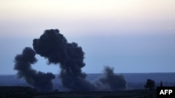 Smoke billows from the embattled village of Baghouz in the northern Syrian Deir Ezzor province on Feb. 19, 2019 during air strikes by the US-backed coalition against the Islamic State group.