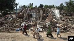 Afghan refugees evacuating a flood devastated area of Azakhel Camp near Nowshera, Pakistan, 16 Aug 2010