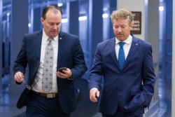FILE - Senators Mike Lee and Rand Paul, both Republicans, walk to a vote on Capitol Hill, in Washington, June 27, 2019.