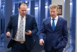 FILE - Senators Mike Lee, left, and Rand Paul, both Republicans, walk to a vote on Capitol Hill, in Washington, June 27, 2019.