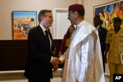 Menteri Luar Negeri AS Antony Blinken, kiri, berjabat tangan dengan Presiden Nigeria Mohamed Bazoum selama pertemuan mereka di istana kepresidenan di Niamey, Niger, Kamis, 16 Maret 2023. (Foto: via AP)