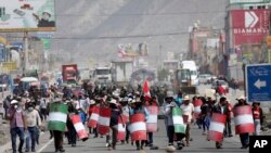 Los llamados activistas de "primera línea" marchan con escudos improvisados durante una protesta contra el gobierno y el Congreso de la presidenta Dina Boluarte, en Arequipa, sur de Perú, el miércoles 4 de enero de 2023.