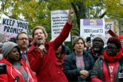 Democratic presidential candidate Elizabeth Warren calls for people across the country to support striking Chicago teachers after joining educators picketing outside an elementary school, Oct. 22, 2019, in Chicago.
