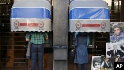 In this Saturday, April 4, 2015 photo, Iranians use ATM machines of Bank Melli Iran in downtown Tehran, Iran. Should Iran reach a final nuclear accord with world powers that loosens sanctions, the economic opening could give moderates a major boost…