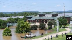 FILE - Local residents watch as the Arkansas River floods Harry E. Kelley River Park, May 30, 2019, in Fort Smith, Ark.