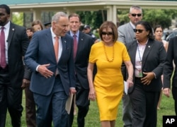 FILE - Senate Minority Leader Chuck Schumer, left, and Speaker of the House Nancy Pelosi walk together at the Capitol in Washington, June 20, 2019.