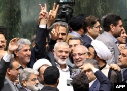 Ismael Haniyeh, pemimpin Palestina dari kelompok militan Hamas, dikelilingi oleh anggota parlemen pada upacara pelantikan Presiden Iran yang baru, di parlemen Iran di Teheran, 30 Juli 2024. (AFP)