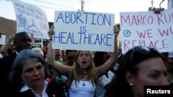 Une manifestante des droits à l'avortement tient une pancarte alors qu'elle manifeste après que la Cour suprême des États-Unis a statué dans l'affaire d'avortement Dobbs contre Women's Health Organization à Miami, le 24 juin 2022.