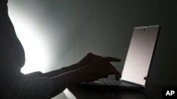 FILE - In this, Monday, Dec. 12, 2016, file photo illustration, a person types on a laptop, in Miami. 