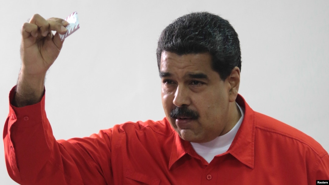 Presiden Venezuela Nicolas Maduro menunjukkan kertas suaranya saat memberikan suara di Caracas, Minggu (30/7) lalu. 