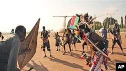 Former militia leader Gabriel Tanginye, left, participates in a traditional dance with dancers from the Nuer tribe at the Juba airport upon his arrival in the southern capital to hold peace talks with the president and army leadership, 14 Oct 2010 (file p