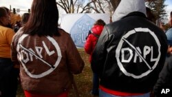 Cousins Jessica and Michelle Decoteau of Belcourt don slogans opposing the Dakota Access Pipeline in Bismarck, North Dakota, Oct. 29, 2016.