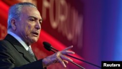 FILE - Brazil's President Michel Temer gestures as he attends an economics and politics forum in Sao Paulo, Brazil, Sept. 30, 2016. 