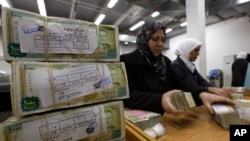 FILE - Employees stack Syrian currency in the Central Bank, in Damascus, Syria, Jan. 13, 2010. 