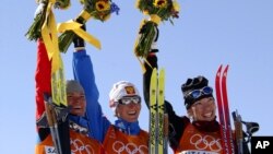 De gauche à droite, la médaillée d'argent Larissa Lazutina, de Russie, la médaillée d'or Olga Danilova et la médaillée de bronze Beckie Scott, du Canada, lors de leur sacre à la course féminine de cinq kilomètres aux Jeux olympiques d'hiver le vendredi 15 février 2018.