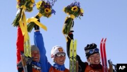 De gauche à droite, la médaillée d'argent Larissa Lazutina, de la Russie, la médaillée d'or Olga Danilova, de la Russie, et la médaillée de bronze Beckie Scott, du Canada, célébrant leur victoire en cross-country de 5 km aux Jeux olympiques d'hiver.